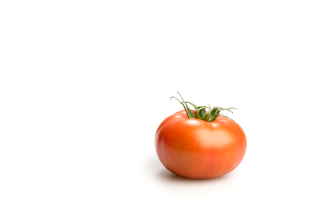 One realistic looking fresh red tomato isolated on a white background sideviewの写真素材