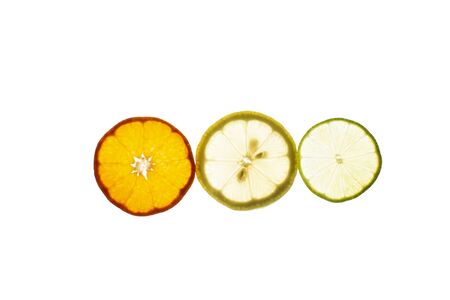 Three slices of lemon, tangerine and lime fruit with light shining through backlight showing the structure and details isolated on a white backgroundの写真素材