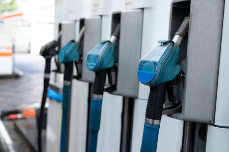 A row with four blue gas pump nozzles in landscape