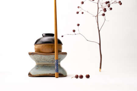 A still life of a japanese figure built from cups and a chopstick isolated on a white backgroundの写真素材