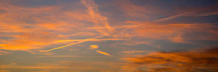 Dramatic red yellow and blue sky at dusk the setting of the evening, a panoramaの写真素材