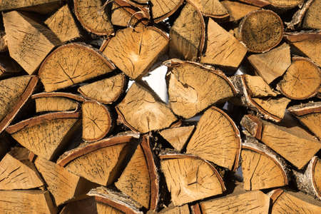 Pile of neatly stacked chopped timber logs for the fireplaceの写真素材