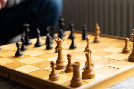 A game of chess being played, view on the board with part of an unrecognizable man