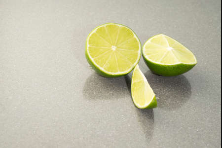 A Natural fresh green lime sliced on a gray stone backgroundの写真素材