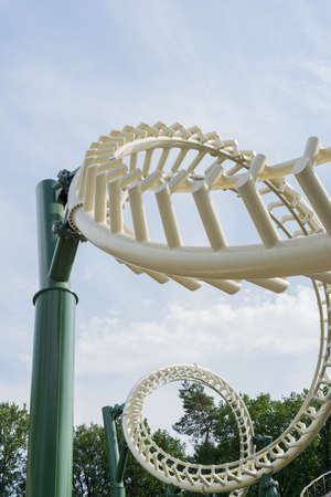 Perspective view of two inverted loops of a roller coaster against a blue and cloudy skyの写真素材