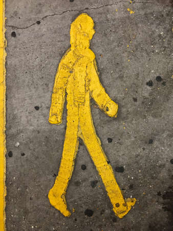 a Sign of a yellow person walking on the floor in a parkinglotの写真素材