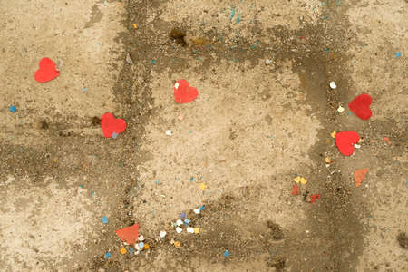 a Weathered concrete floor with rubbish and confetti and heart shapesの写真素材