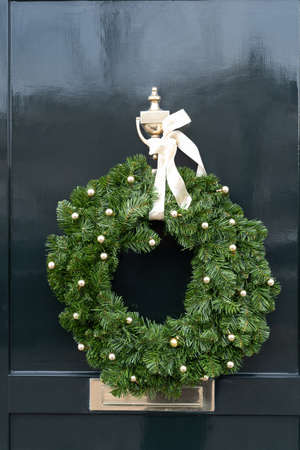 Beautiful door is decorated for Christmas with an evergreen wreathの写真素材