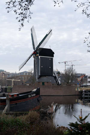 Dutch city Leiden in autumn. Windmill and old boat