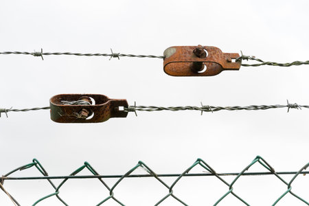 Barbed or barb wire fence against skyの写真素材