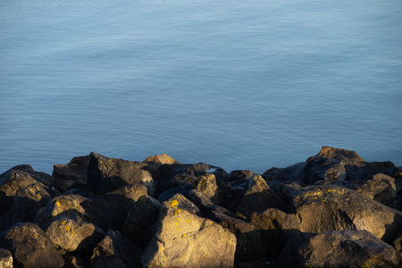 Boulders on Waters Edge at sea a lot of stones on the shoreの写真素材