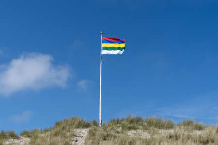 The Flag of Terschelling - one of the Wadden islands in The Netherlands - flying on the sand duneの写真素材