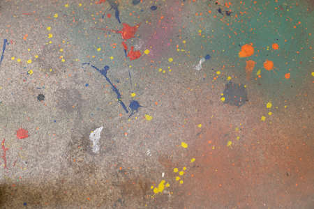 Some Colorful and splattered paint over a cracked surface or concrete floorの写真素材