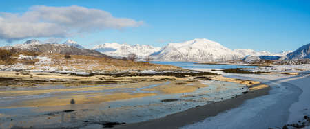 The View at the ocean and the fjord in the Atlantic Ocean with a snowy icy river in the polar area and mountains covered in snow near in Sommaroy Tromso Norwayの写真素材
