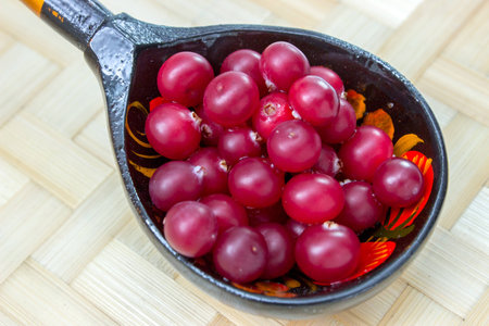 Ripe cranberries, rolled in a wooden spoon.