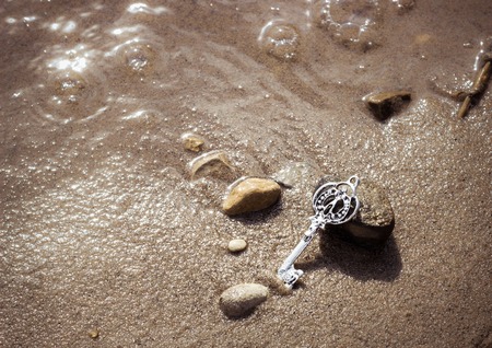 Key in the river sand. Photo toned.