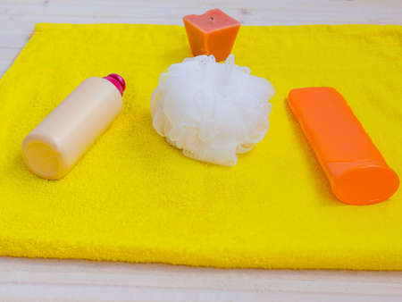 shower gel yellow towel aroma candle and body lotion