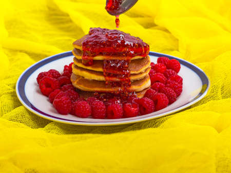 pancakes with ripe raspberries and raspberry jam on a plate spoonの写真素材