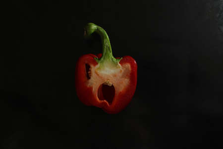 Cut red bell pepper on a black background