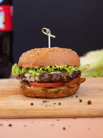 big burger in a cafe on a wooden tableの写真素材