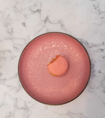 bitten pink macarons on a pink plate.の写真素材