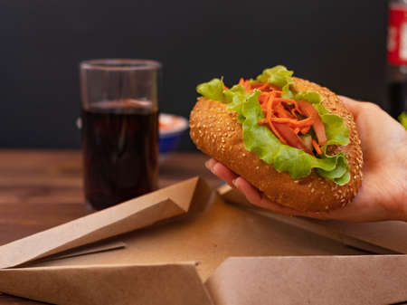 fresh hot dog in hand first personの写真素材