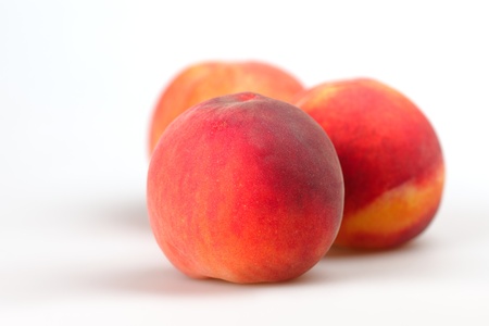 Three peach on a white background closeup の写真素材