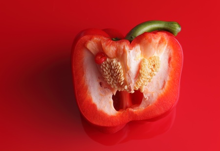 Half of red sweet pepper on a red backgroundの写真素材