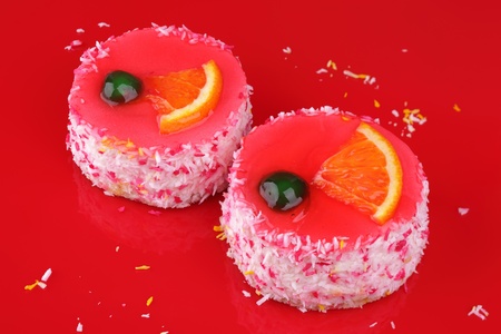 Yogurt cakes in a coconut shaving on red background の写真素材