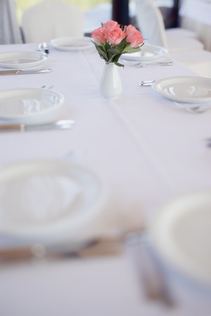 Bouquet of roses on a table in wedding day, table setting, selective focus.の写真素材