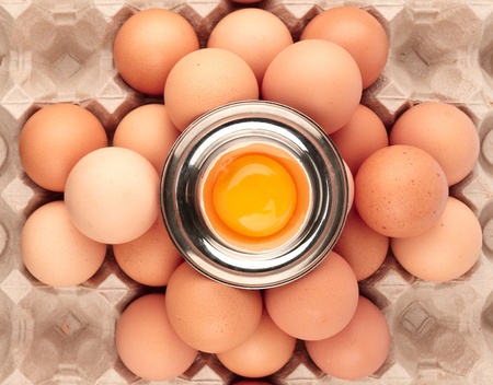 Pyramid of raw brown eggs and egg cup, top view