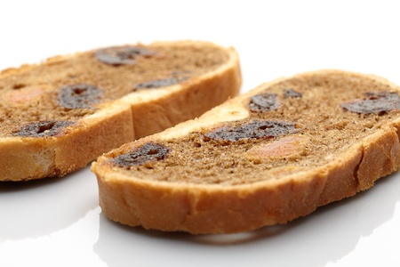 Two pieces of loaf with dried fruit on white background  Small depth of field の写真素材