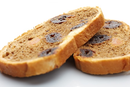 Two pieces of loaf with dried fruit on white background  Small depth of field の写真素材