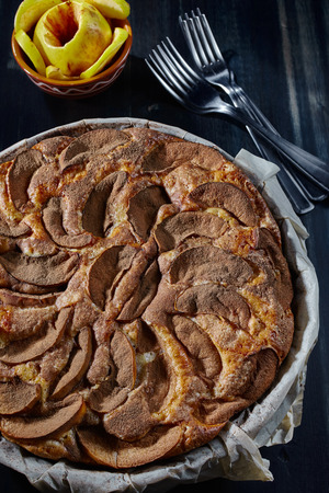 Charlotte with apples and cinnamon on a wooden table, close-up, top view, vertical.の写真素材