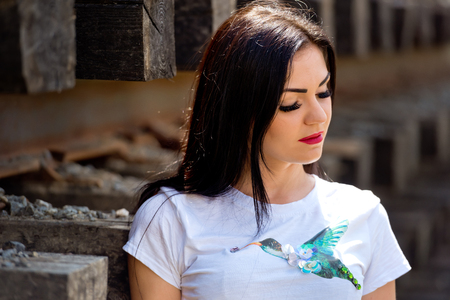Portrait of a beautiful brunette that stands near the railway tracks. Close-up.の写真素材