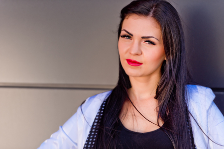 Portrait of a beautiful brunette that stands near a black wall. Close-up.の写真素材