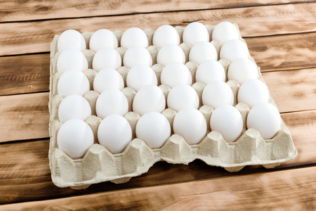Eggs in tray of carton on wooden background.の写真素材