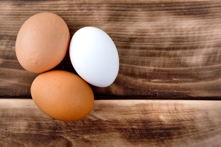 Three easter eggs on a wooden dark table. Food ingredient. Close up.の写真素材