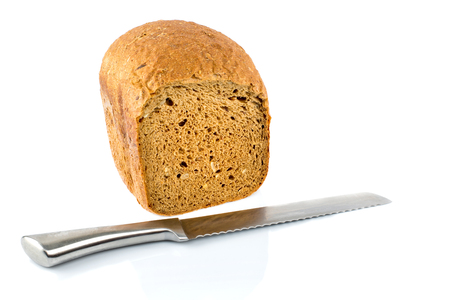 Fresh bread slice and a bread knife isolated on white background. Selective focus.の写真素材