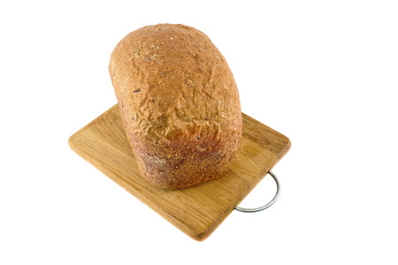 Freshly baked bread on wooden cutting board isolated on white background.の写真素材