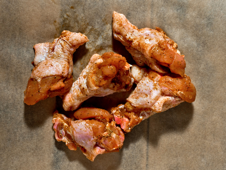 Raw marinated chicken wings on parchment -  ready for cooking.の写真素材