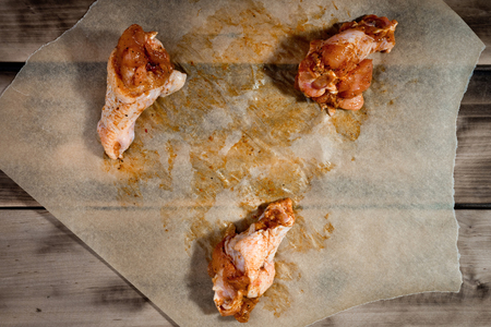 Raw marinated chicken wings on parchment -  ready for cooking.の写真素材
