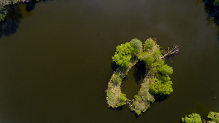 Aerial view of the small island in the city lake. Top view.