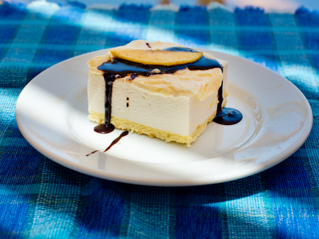Vanilla mousse with chocolate and a slice of fresh apple on a blue tablecloth.の写真素材