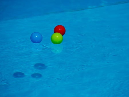 Multicolored balls on the surface of the blue pool.