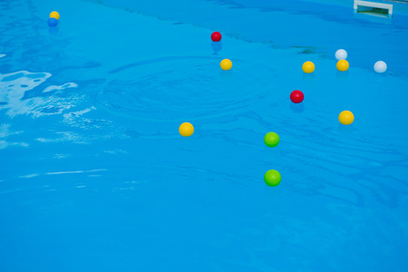 Multicolored balls on the surface of the blue pool.の写真素材