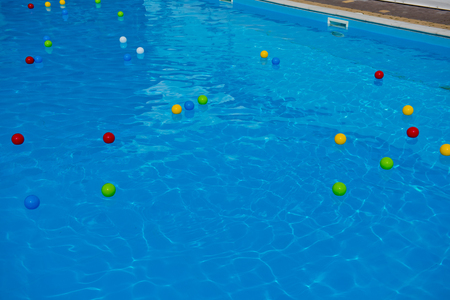 Multicolored balls on the surface of the blue pool.の写真素材