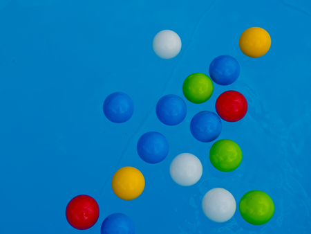 Multicolored balls on the surface of the blue pool.の写真素材