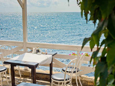 A table in the summer empty cafe by the sea.の写真素材