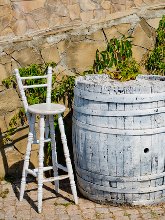 A barrel in the form of a table is painted white and a chair. Concept of a street cafe.の写真素材